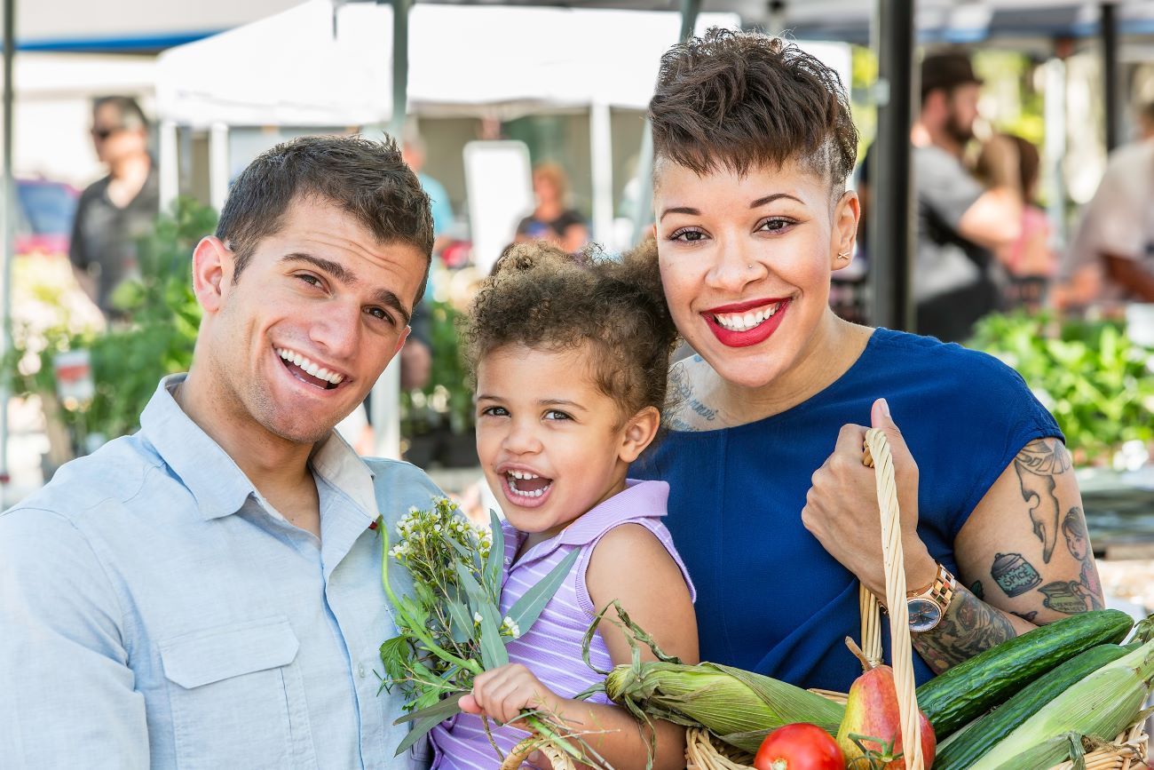 Happy smiling family buying local at farmers' market