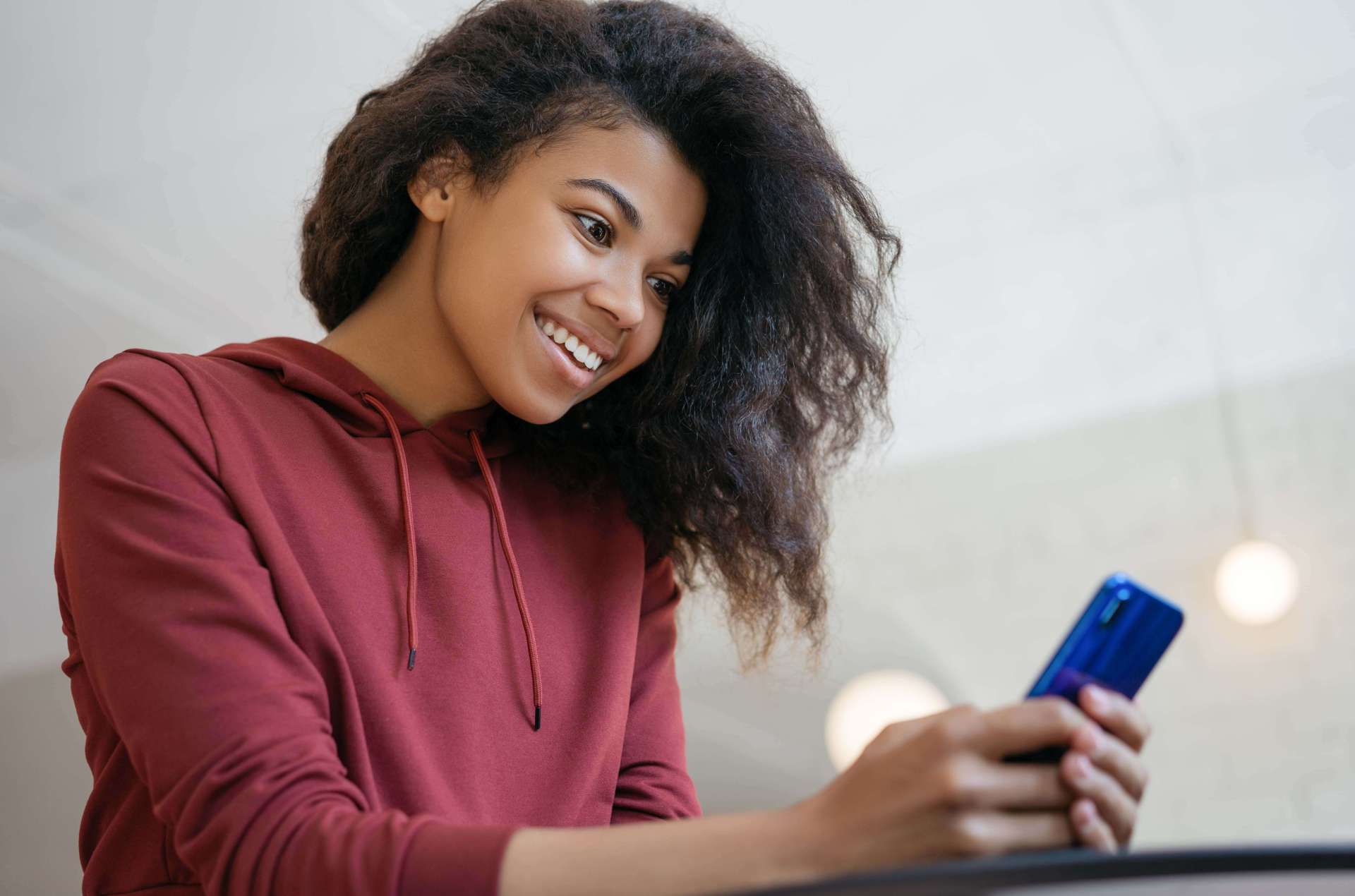 A teenage girl using the Mydoh money app on her phone