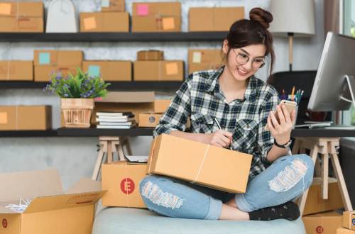 A teenage girl packing boxes for her dropshipping business