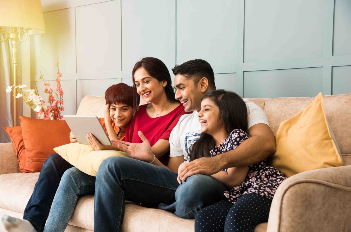 Family sitting together on couch learning about money