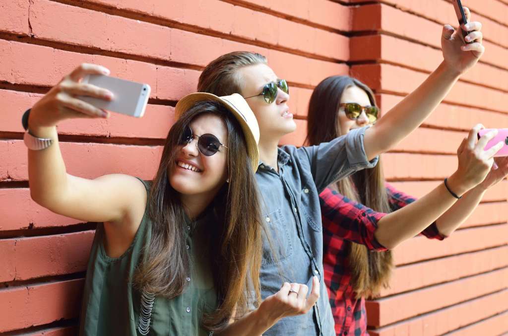 Teenagers taking selfies for social media