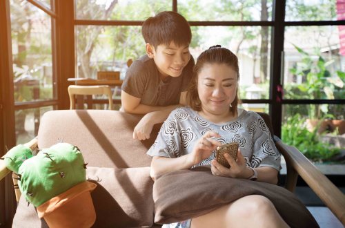 Mom and her son setting up an account on the Mydoh money management app for kids