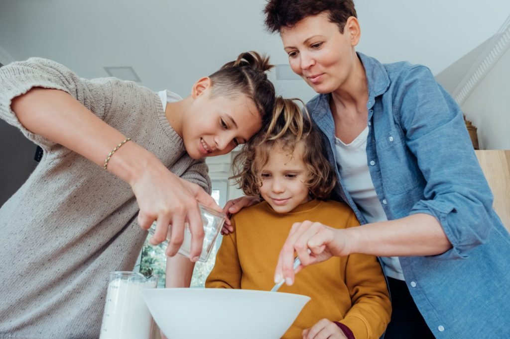 Two teen boys with a woman baking together