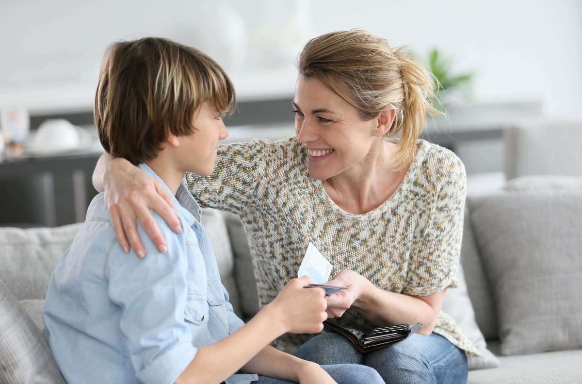 A mother giving her young child money for an allowance