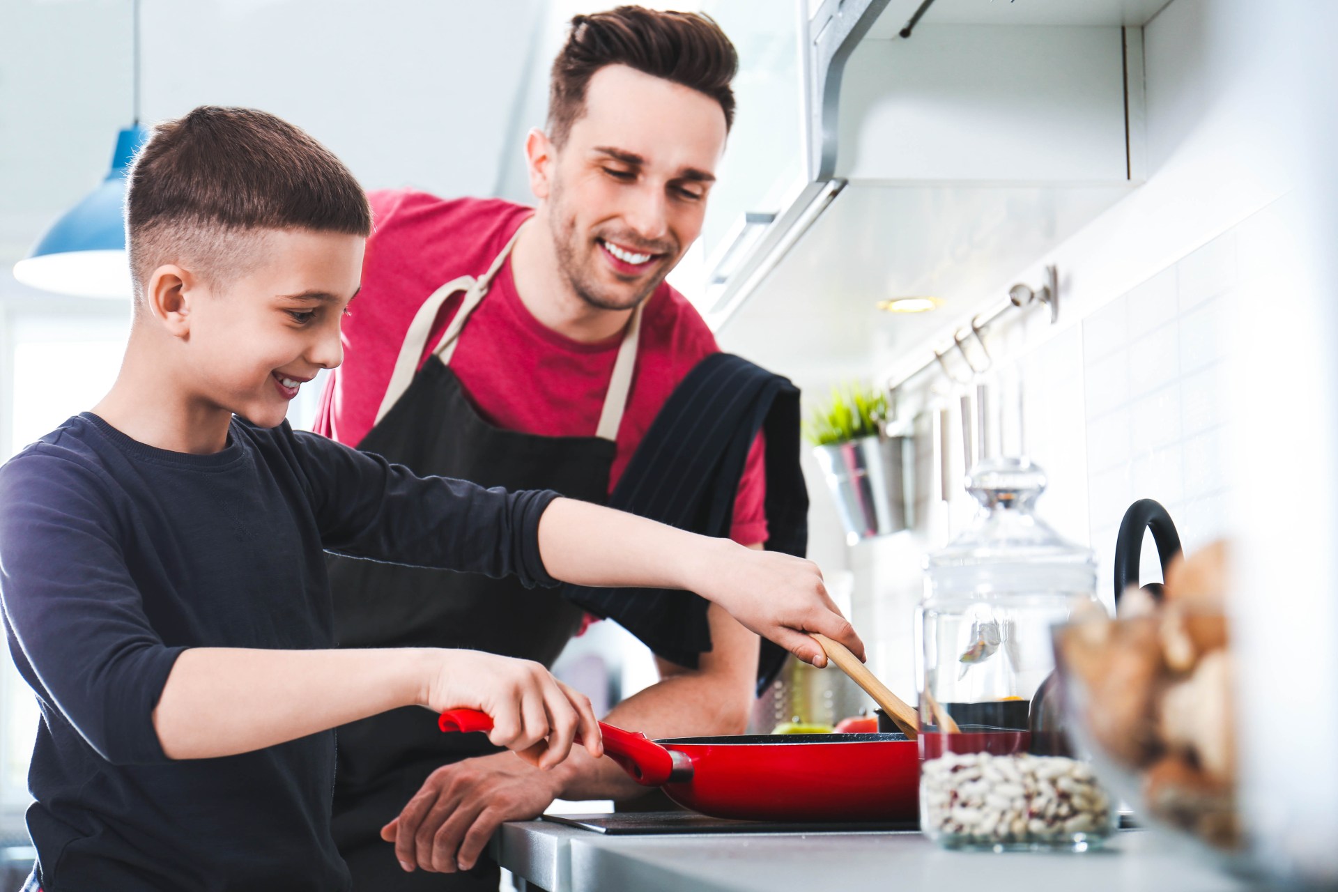 Dad and son cooking together in kitchen