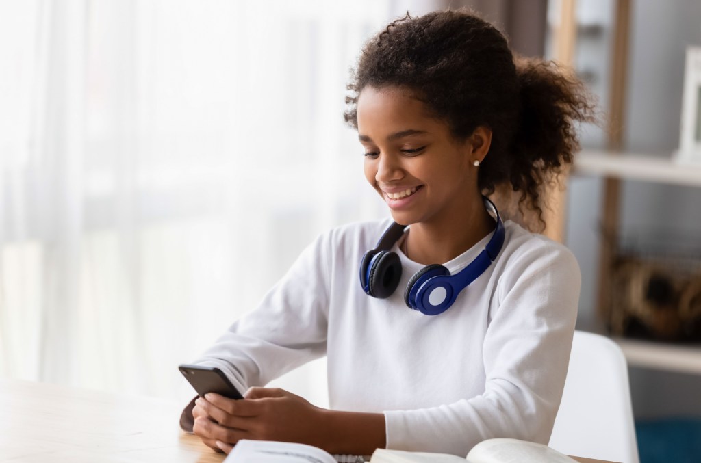 A teen girl using Instagram on her phone