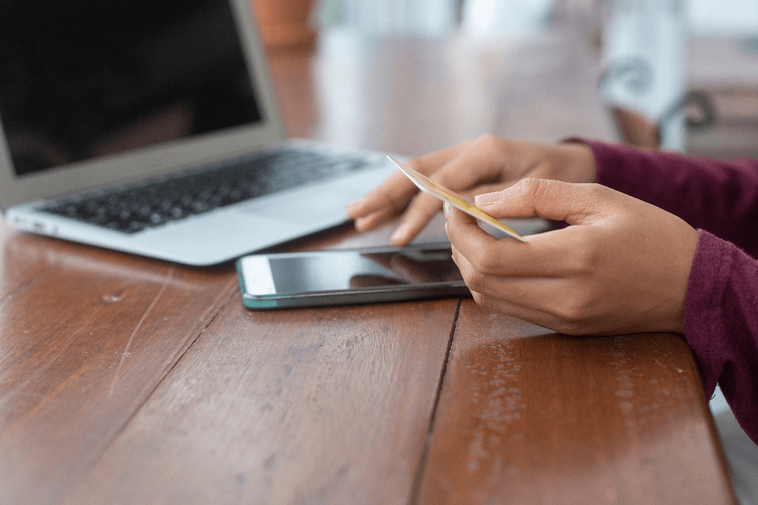 A teen holding a credit card for mobile banking