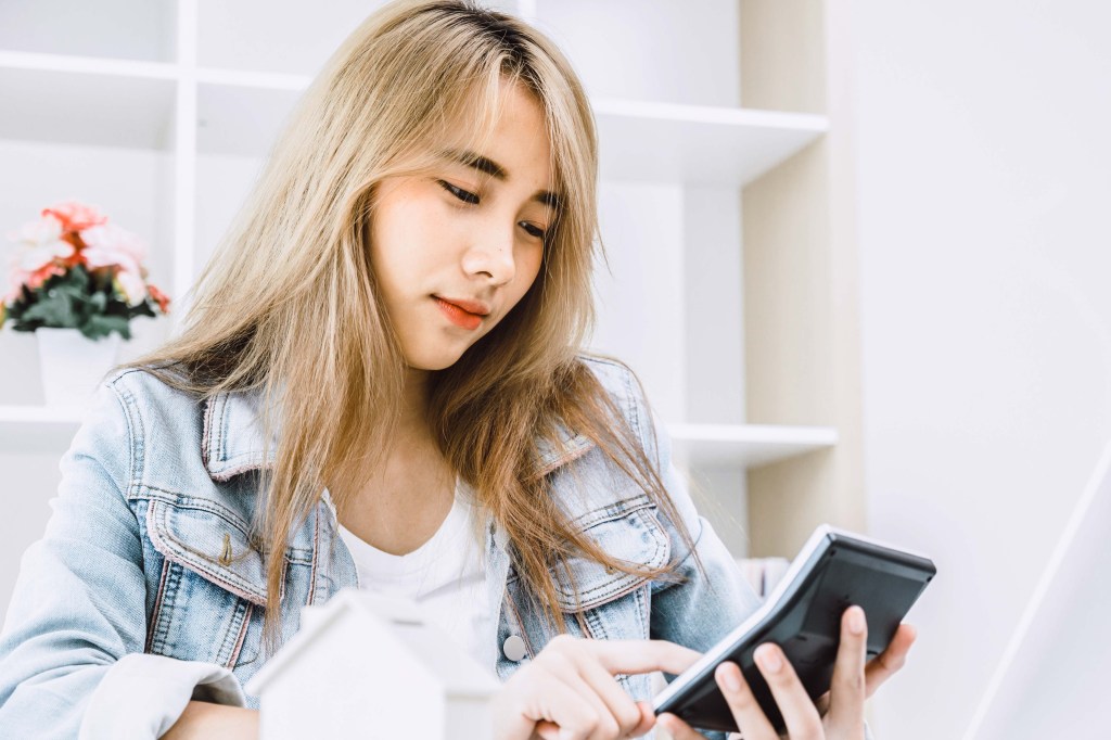 A young girl teen using a calculator to create a budget 