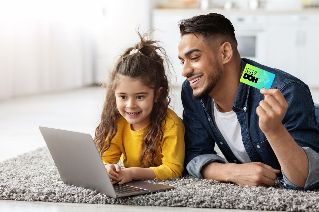 A dad teaching his daughter how to use a credit card