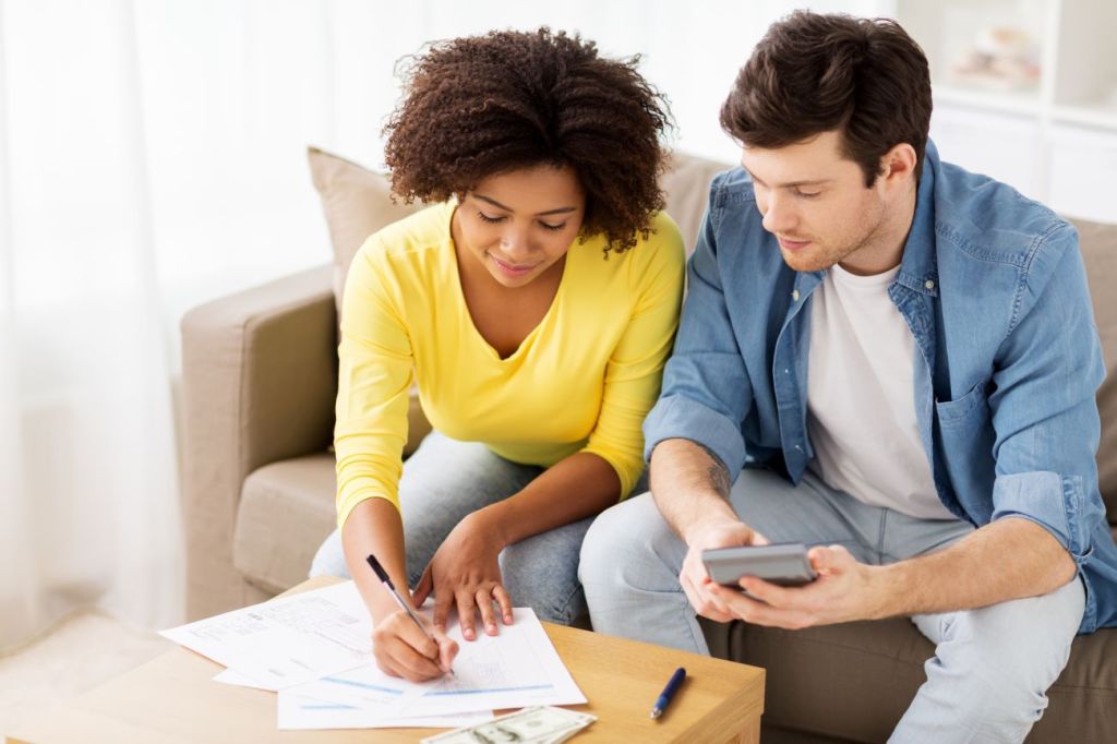 man and woman sitting on couch creating family budget