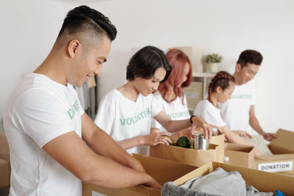 Group of teens and young adults volunteering by sorting out food donations