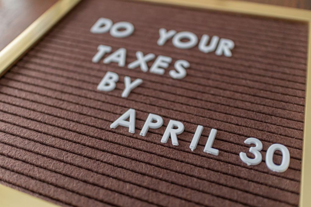 Brown letter board with white letters spelling out do your taxes by April 30