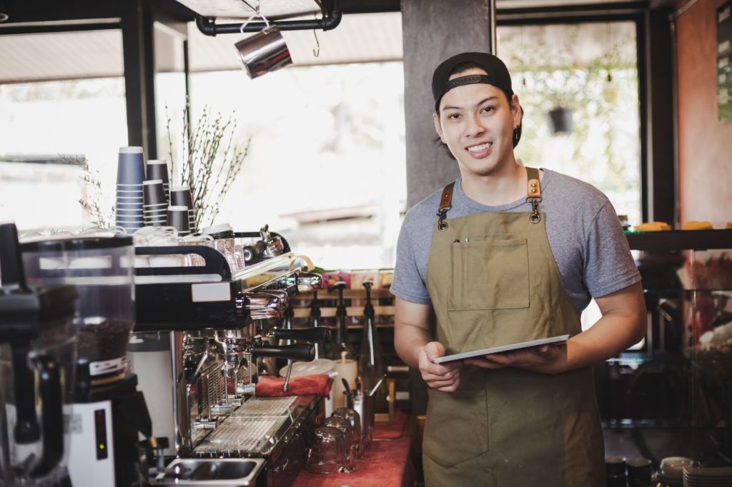 A teen boy working part-time as a coffee barista