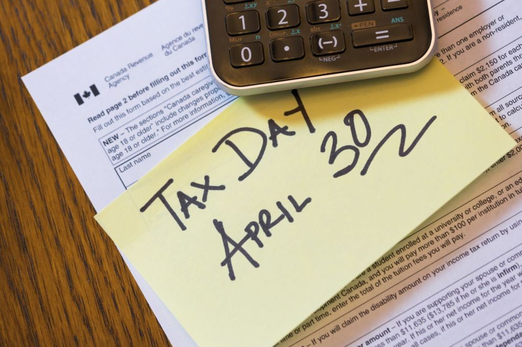 A CRA form and post-it-note with "Tax Day April 30" written on it