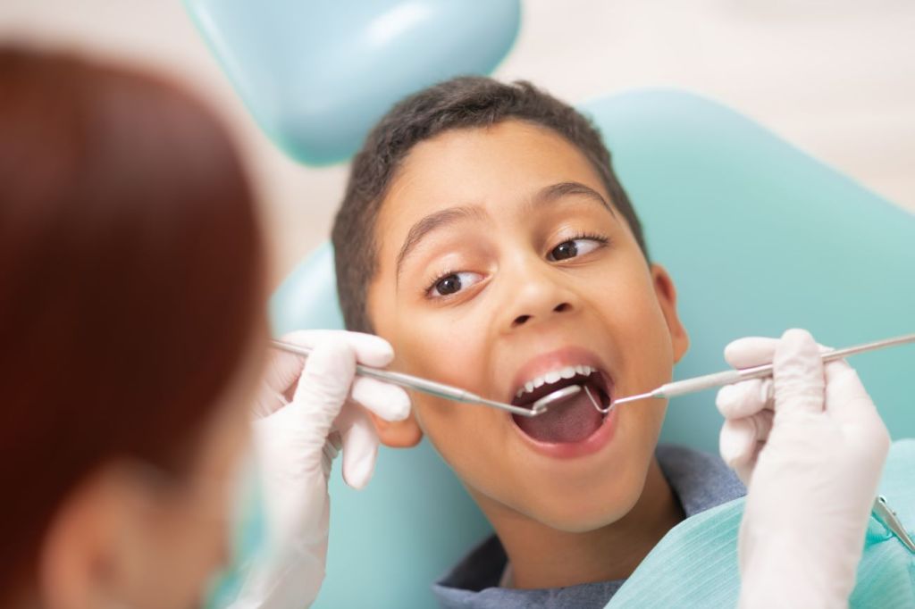 A young boy covered getting his teeth checked covered by dental insurance 