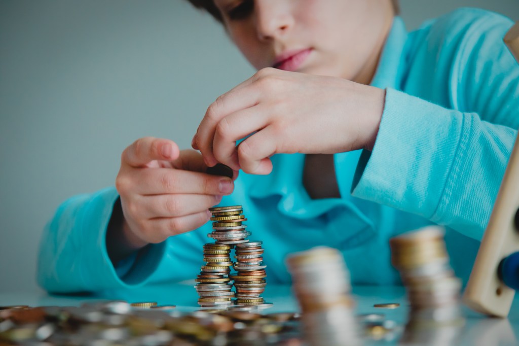 A young boy stacking coins