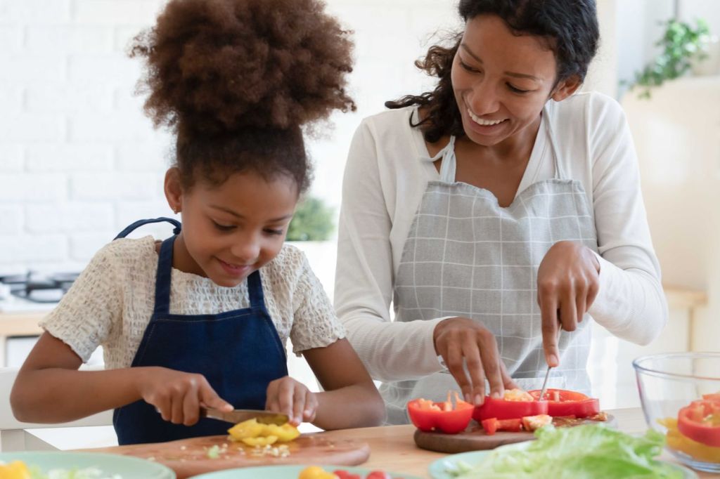 A child helping her mom cook