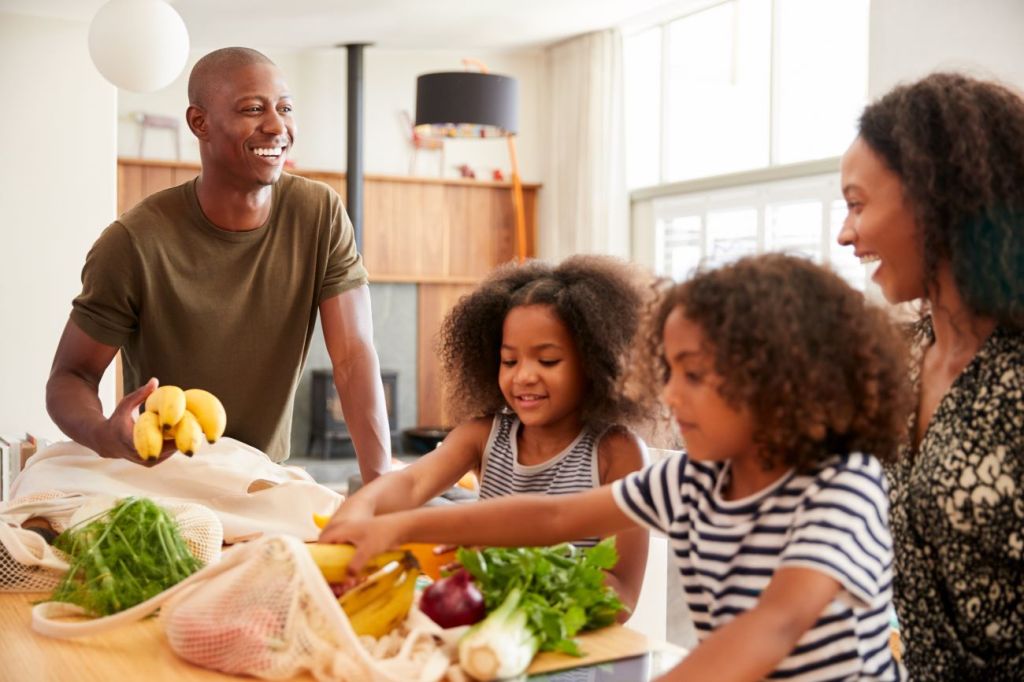 A family, impacted by rising food prices, unpacking groceries together