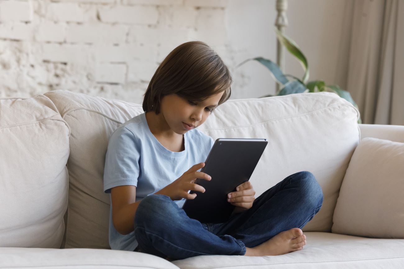 Boy in blue tshirt holding iPad