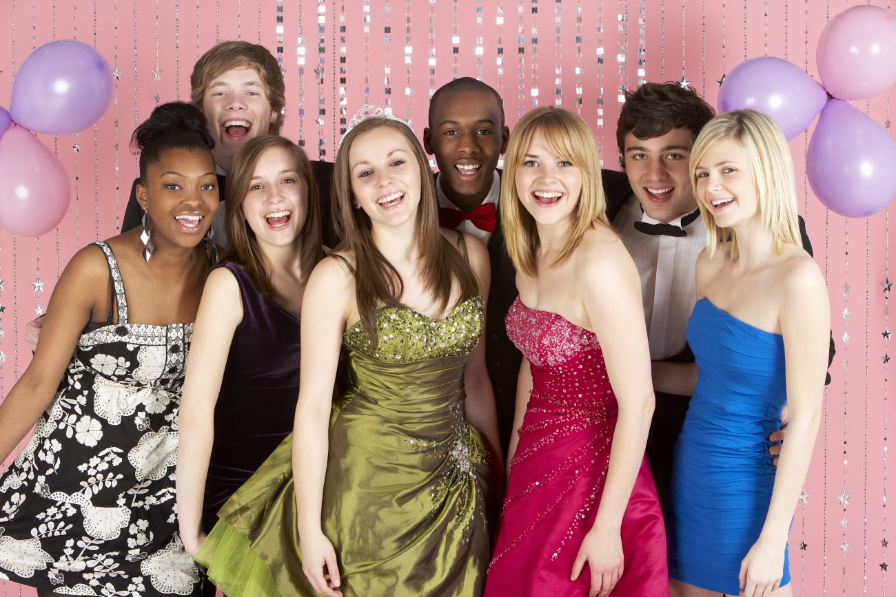 A group of smiling teenagers celebrating prom