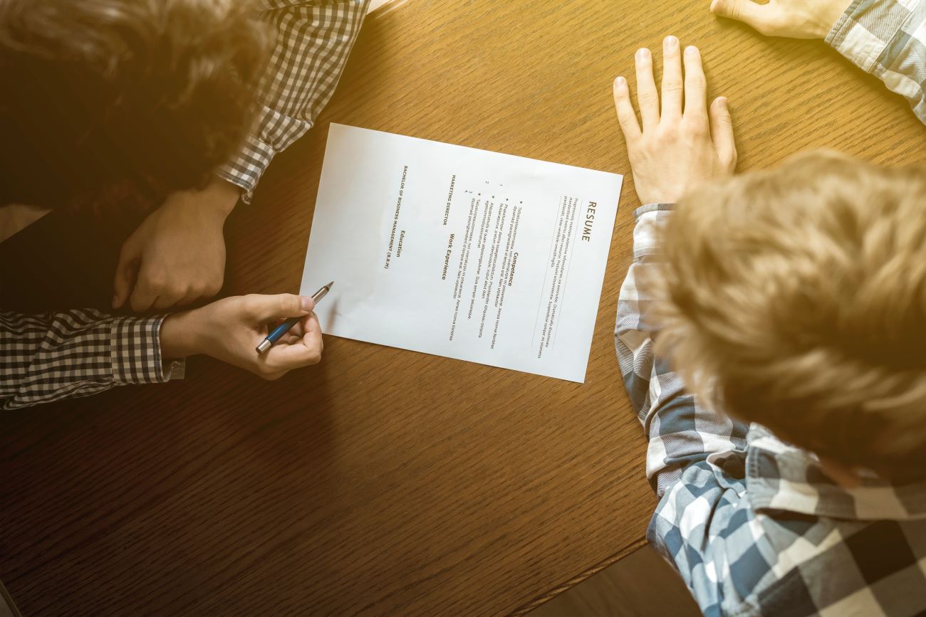 Teen giving their resume to adult in interview