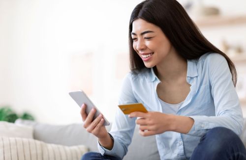 Teen girl looks at her bank statement online and holds bank acard
