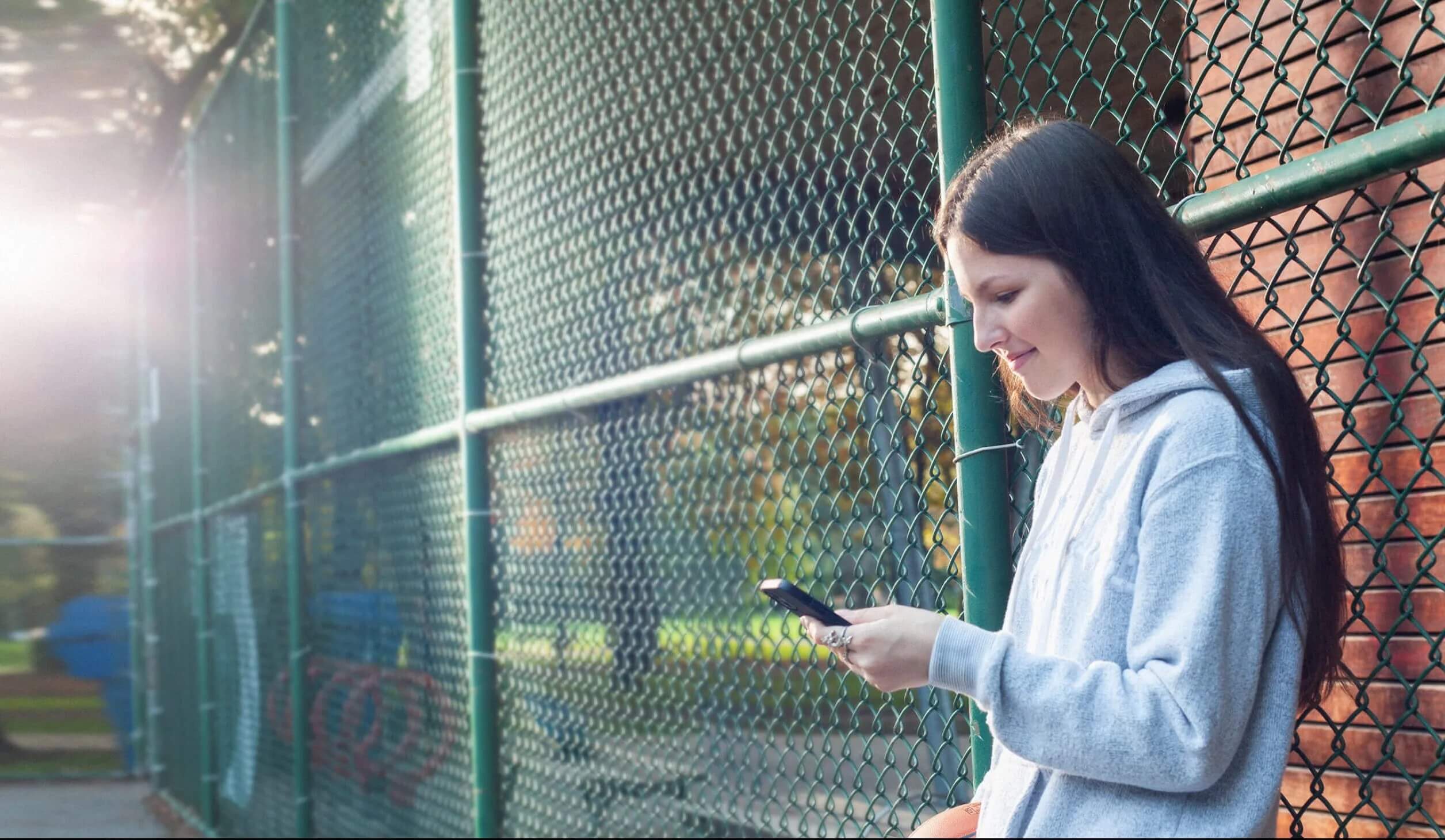 Teenager at park using smartphone