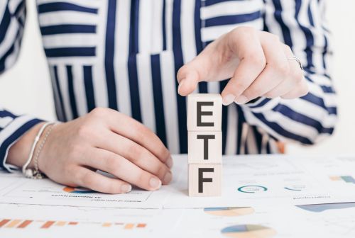 Woman holds blocks spelling ETF exchange traded funds