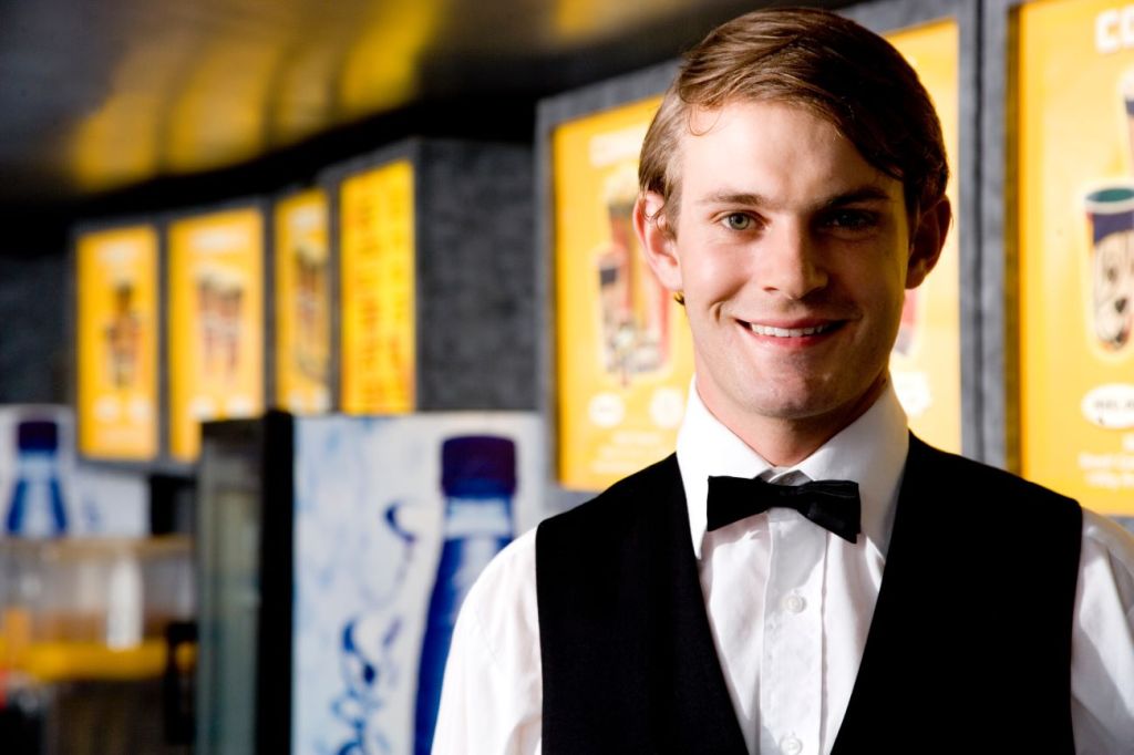 A teenager working as an usher at a movie theatre during high school