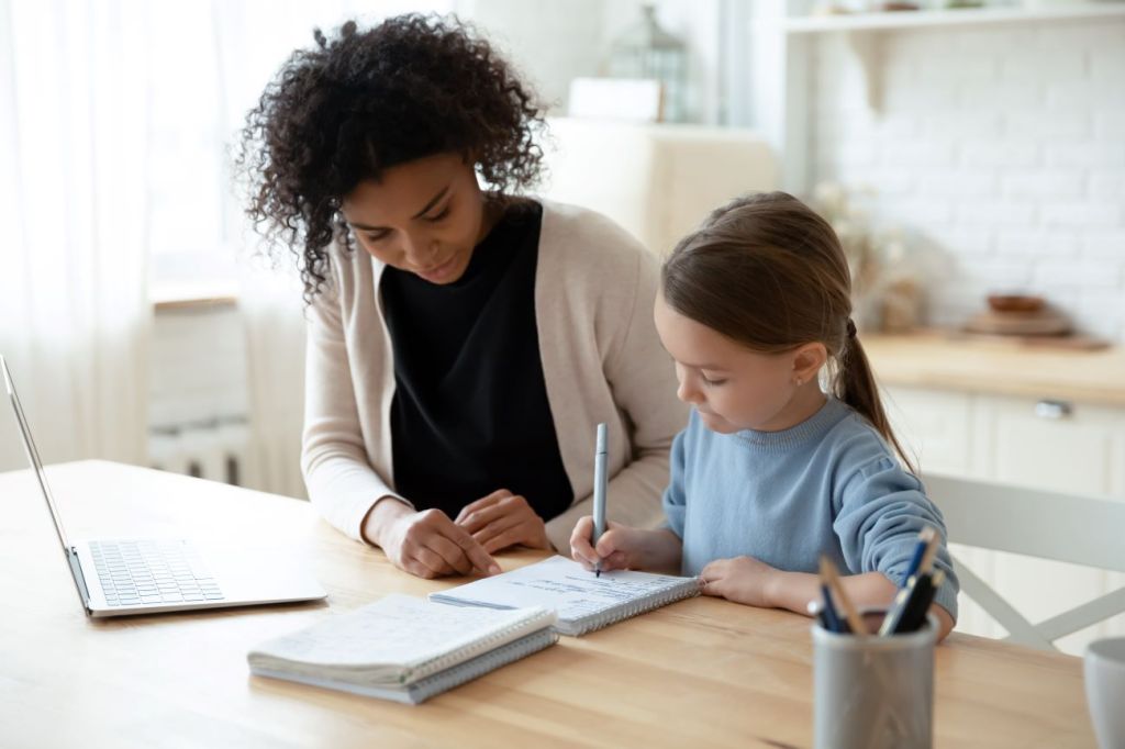 A 16-year old girl working with a young girl as a tutor to earn extra money during the school year