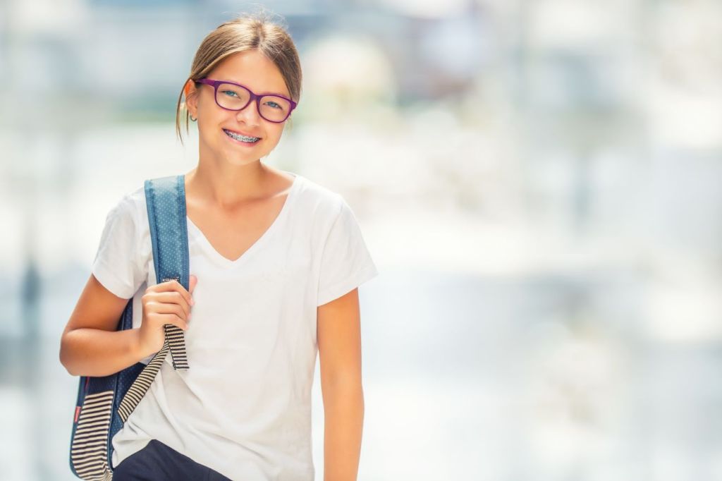 Smiling teen girl with backpack going back to school