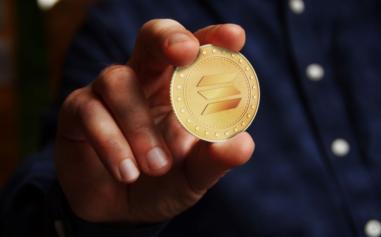Man holding a solana cryptocurrency coin
