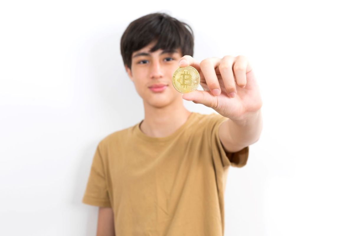 Teen boy holding Bitcoin