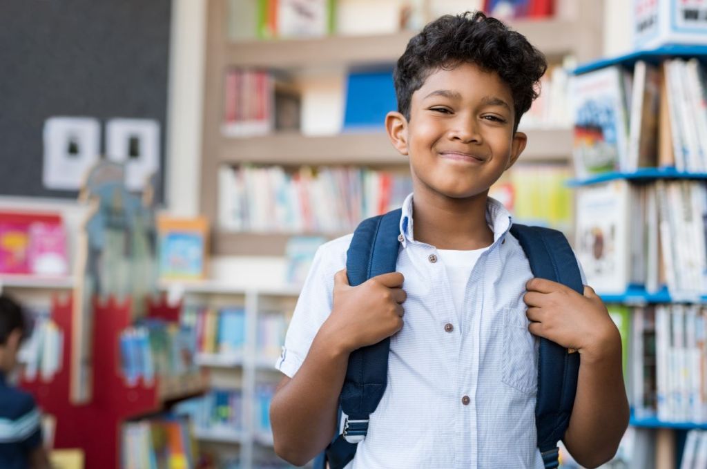 Smiling boy on first day back to school in classroom