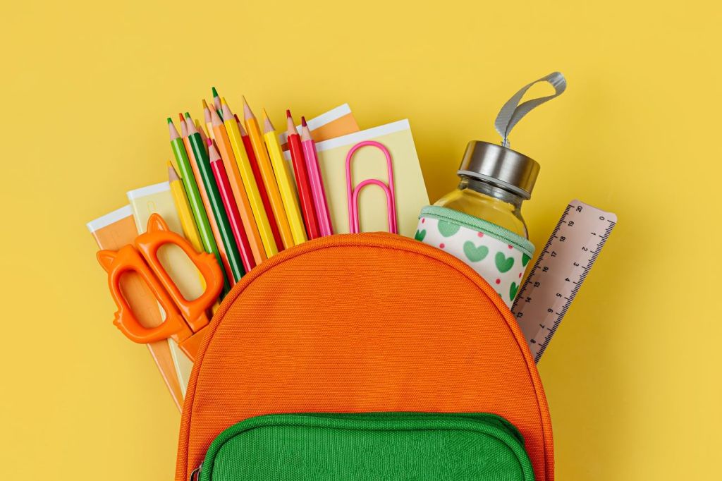 elementary school supplies in colourful backpack