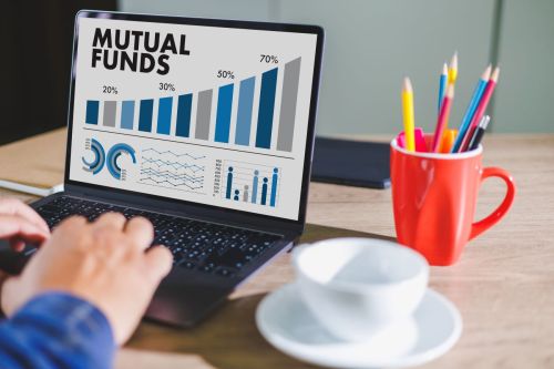 Person types into laptop which reads "Mutual Funds" on the screen
