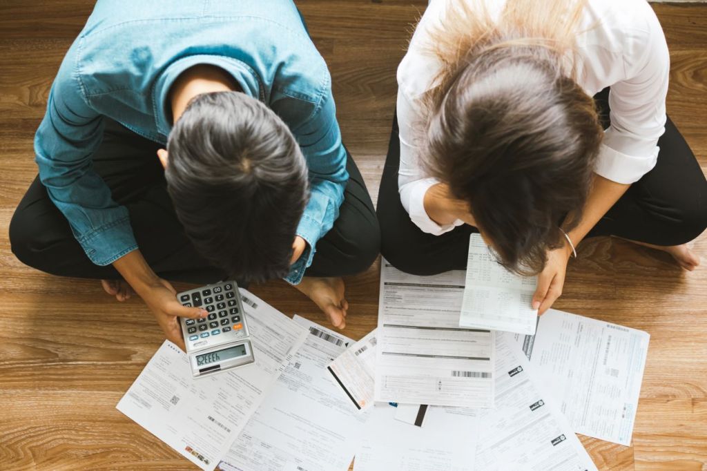 aerial view of man and woman looking at bank statements consolidating debt