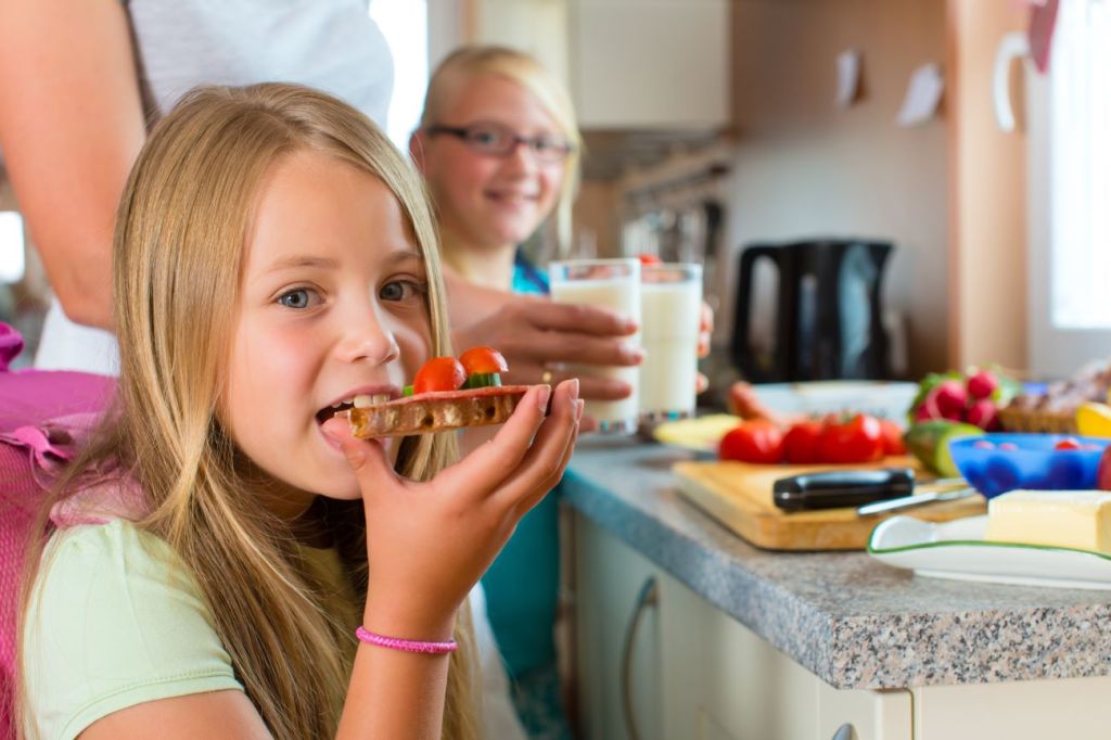 A mom and her two girls starting their morning routine with breakfast and milk