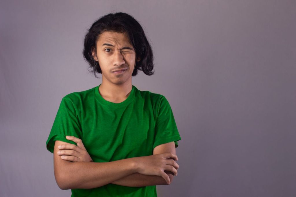 Teen boy in green tshirt thinking about investing and risk