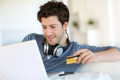 young man wearing headphones holding credit card
