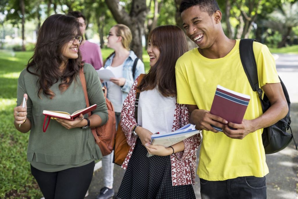 group of young adults in university laughing and talking