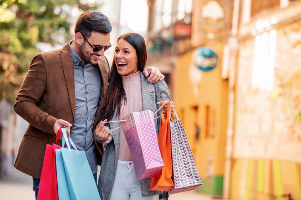 Man and woman smiling and laughing with shopping bags