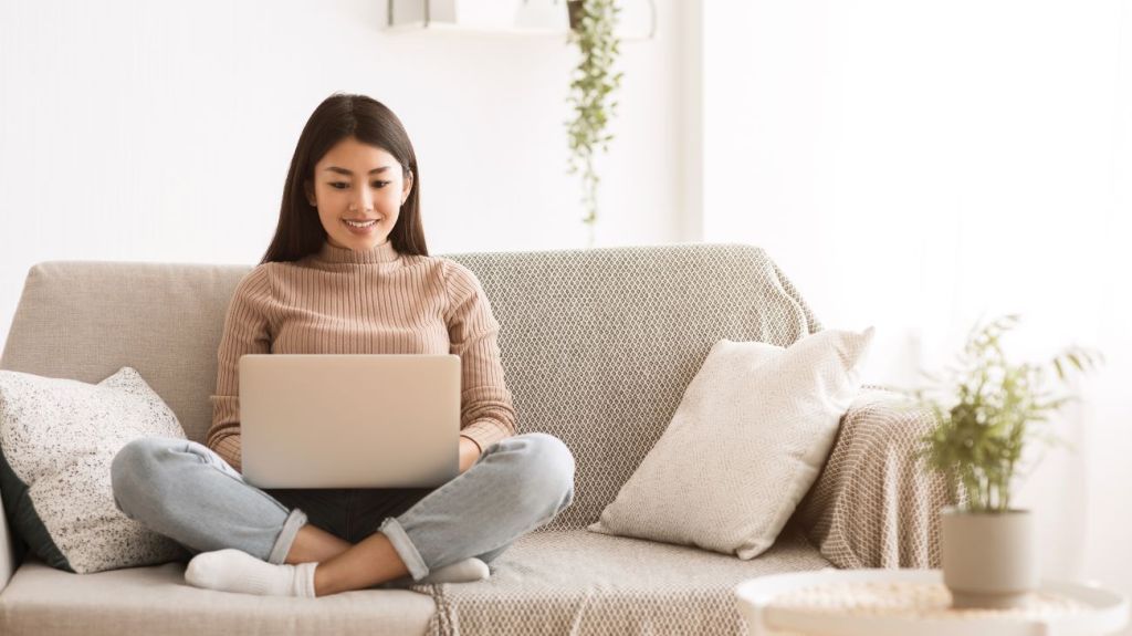 Teen girl on couch using computer 