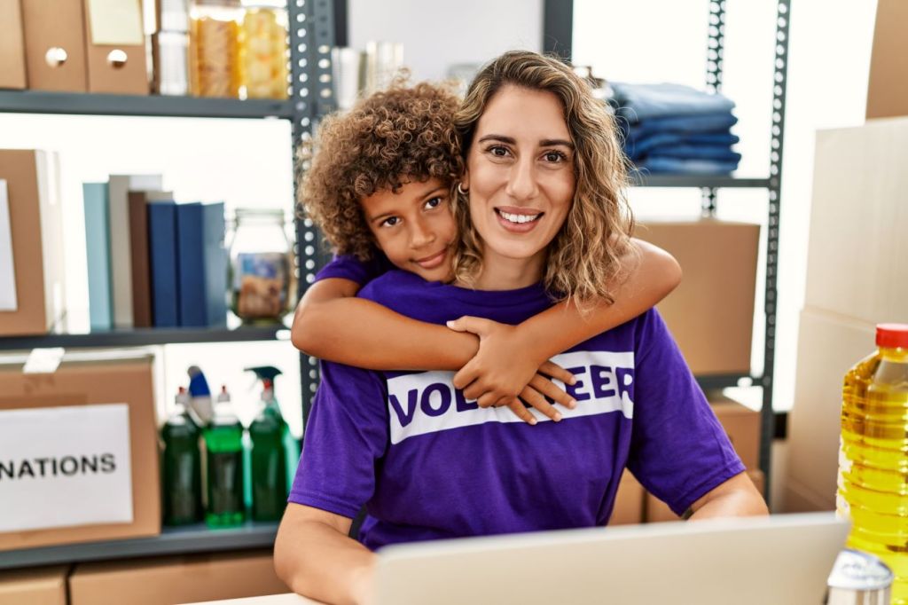 Boy hugs woman both wearing purple volunteer t-shirts