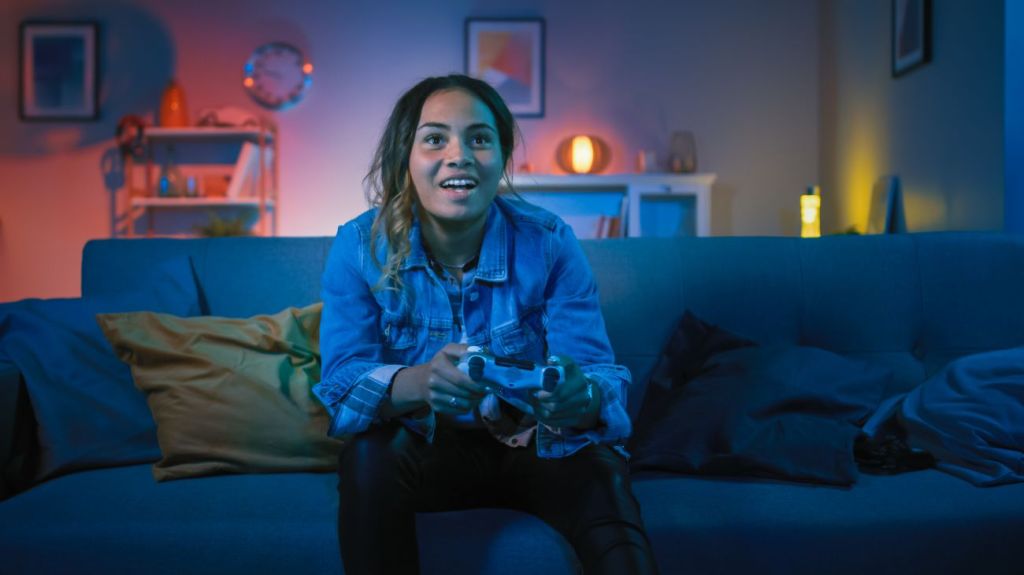 Teen girl sitting on couch playing video games