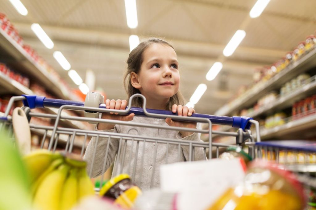 girl pushing shopping cart in supermarket