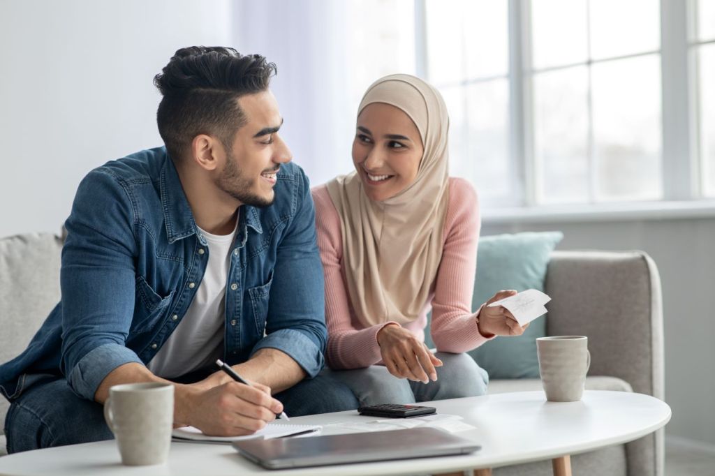 man and woman sitting on couch making a budget