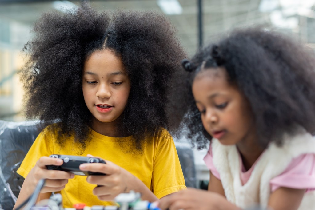 Two Black girls playing with machine learning