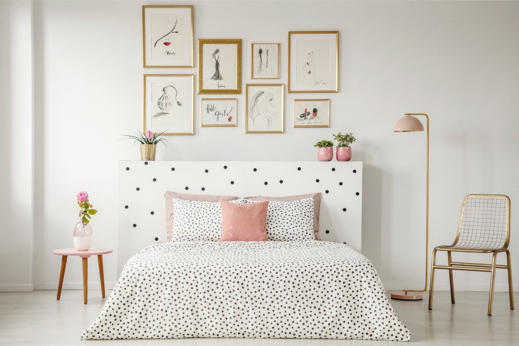 Beautiful teen bedroom with bed, and wall art gallery in the background