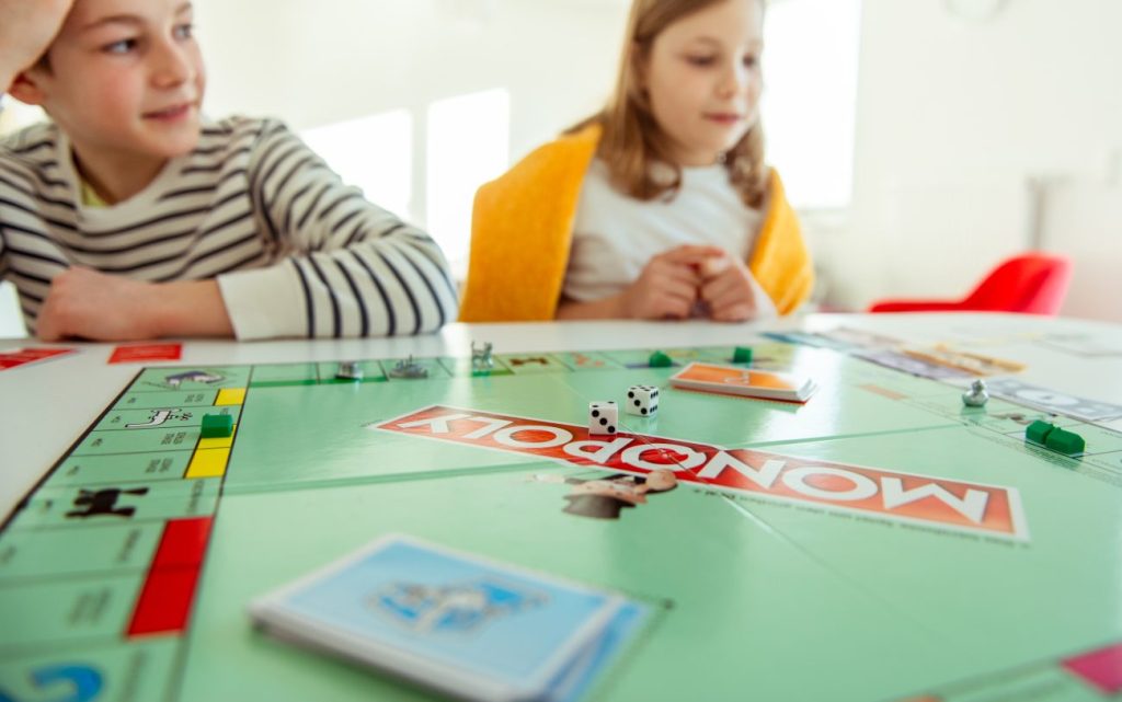 Boy and girl playing a game of Monopoly